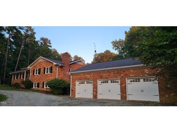 Brick home with a three-car garage and mature trees at 7610 Buckhorn Rd, Hillsborough, NC 27278