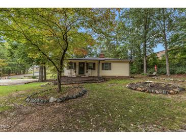 Cozy ranch home with landscaped yard, stone borders, and porch at 9336 Baileywick Rd, Raleigh, NC 27615