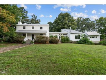 Two-house property with large yard, showcasing a white farmhouse and modern addition at 1021 Dimmocks Mill Rd, Hillsborough, NC 27278