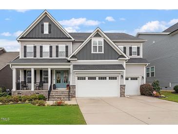 Charming two-story home with a welcoming front porch and a two-car garage at 116 Mystic Quartz Ln, Holly Springs, NC 27540