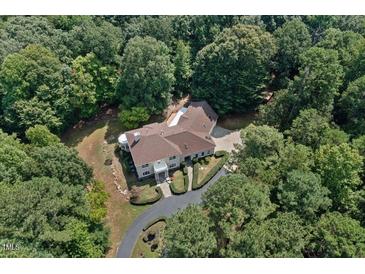 Luxury home nestled in a wooded lot, showcasing a grand exterior and landscaping at 6300 Swallow Cove Ln, Raleigh, NC 27614