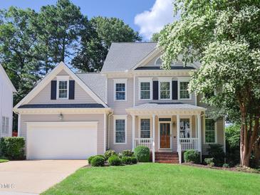 Two-story house with a beige exterior, white trim, and a covered front porch at 102 Preston Pines Dr, Cary, NC 27513