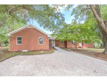 Brick ranch home with gravel driveway and mature landscaping at 2171 Bud Lipscomb Rd, Willow Springs, NC 27592