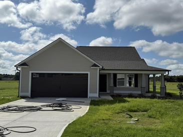 Tan house with dark brown garage door and landscaping at 95 Grace Ridge Ct, Benson, NC 27504