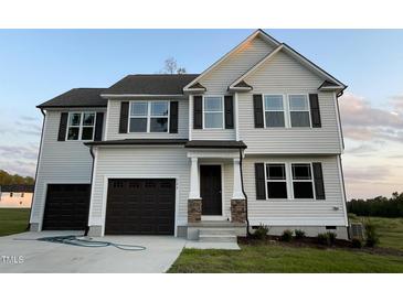 Two story home with a two car garage and landscaped yard at 223 Bonsai Way, Four Oaks, NC 27524
