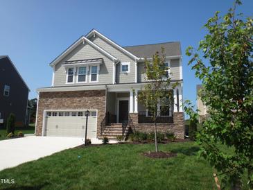 Two-story house with stone and shingle siding, two-car garage, and landscaping at Lot 35 Magnolia Acres Ln, Fuquay Varina, NC 27526