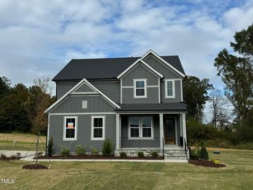 Two story home with gray siding, landscaping, and stone accents at 230 Grading Stick Ct, Angier, NC 27501