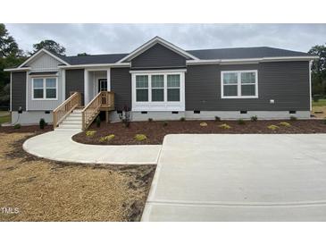 Modern single-story home with gray siding, landscaped yard, and concrete driveway at 6733 Oscar Barham Rd, Wake Forest, NC 27587