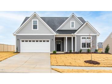 Charming two-story home with gray siding, white trim, and attached two-car garage at 420 Oak Park Blvd, Youngsville, NC 27596