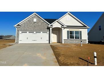 Newly constructed one-story home featuring stone and vinyl siding, a two-car garage, and a concrete driveway at 2738 Lacy Holt Rd, Graham, NC 27253