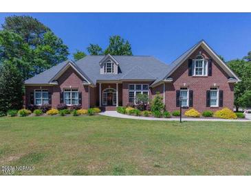 Brick home with a large lawn and mature trees at 512 W Franklin St, Zebulon, NC 27597