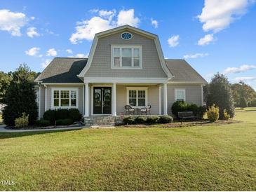 Gray Cape Cod style home with a manicured lawn at 409 Rogers Rd, Zebulon, NC 27597