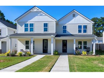 Two-story white house with front porch, landscaping, and walkway at 3010 Garner Rd # 101, Raleigh, NC 27610