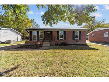 Ranch-style brick house with a neatly kept lawn and landscaping at 1016 Walnut St, Burlington, NC 27217