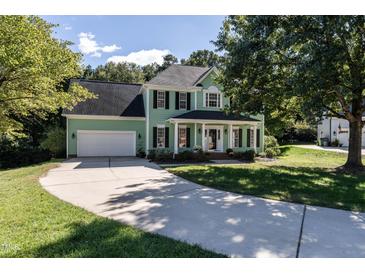 Two-story light green house with a gray roof, attached garage, and a large front yard at 11308 Timbergrove Ln, Raleigh, NC 27614