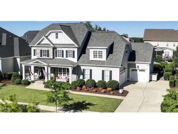 Two-story home with stone accents, welcoming porch, and landscaped yard at 117 Hardy Oaks Way, Holly Springs, NC 27540