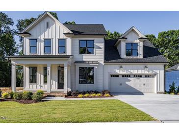 Two story farmhouse style home with a large driveway at 6045 Scalybark Road, Durham, NC 27712