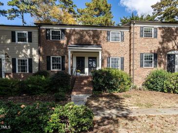 Brick townhouse with double front doors, steps, and landscaping at 3736 Jamestown Cir, Raleigh, NC 27609