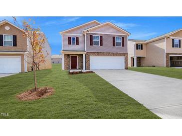 Two-story house with a brown and beige exterior, a two-car garage, and a well-manicured lawn at 1915 Puffin Dr # 198, Haw River, NC 27258