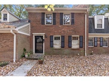Brick front exterior of charming townhome with black door and shutters at 3158 Morningside Dr, Raleigh, NC 27607