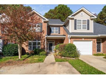 Two-story brick townhouse with a two-car garage and landscaped yard at 2106 White Pond Ct, Apex, NC 27523