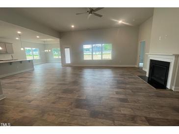 Open living space with tile floors, fireplace, and access to kitchen at 100 Lemon Drop Ln, Franklinton, NC 27525