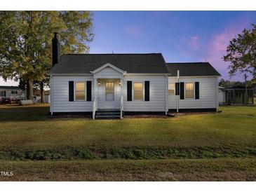 White one-story house with a spacious lawn and a tranquil setting at 2494 Joel Johnson Rd, Lillington, NC 27546