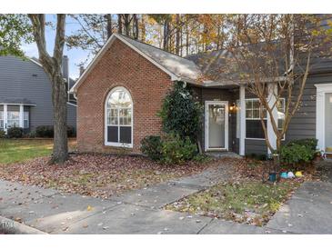 Brick front exterior of charming townhome with gray accents and landscaping at 4445 Still Pines Dr, Raleigh, NC 27613