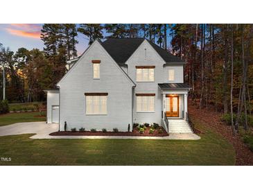 Two-story home with white brick exterior, landscaping, and a two-car garage at 2105 Gentry Rd, Wake Forest, NC 27587
