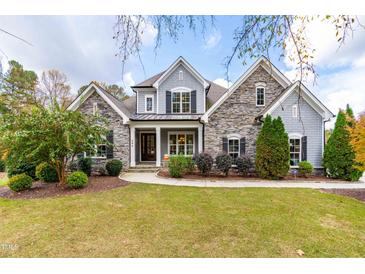 Two-story stone and gray house with a large front yard and landscaping at 204 Harvest Ln, Pittsboro, NC 27312