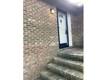 Brick exterior with white front door and steps at 200 W Woodcroft Pkwy # 36A, Durham, NC 27713