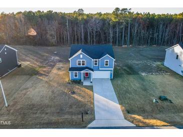 Two-story blue house with driveway and wooded backdrop at 316 Robert Howe Dr, Fuquay Varina, NC 27526