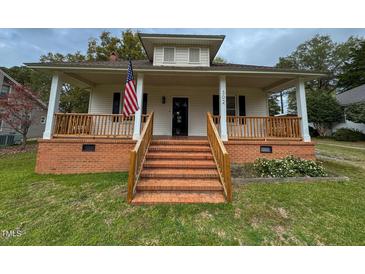 Front view of charming house with porch and brick steps at 302 E D St, Erwin, NC 28339