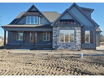 Two-story home with gray siding, stone accents, and a covered porch at 20 Water Willow Ln, Zebulon, NC 27597