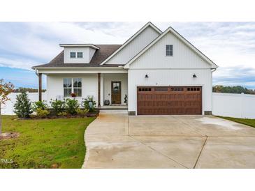 White farmhouse exterior with brown garage door and landscaping at 181 Glenwood Pl, Kenly, NC 27542