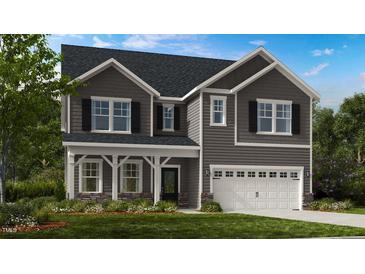Two story home with gray siding, stone accents, and 3 car garage at 904 Delano Dr, Knightdale, NC 27545