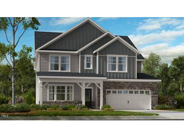 Two story house with gray siding, stone accents, and a two car garage at 905 Delano Dr, Knightdale, NC 27545