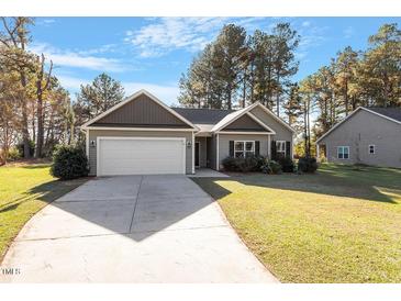 Gray house with white garage door and landscaping at 153 Highland Dr, Lillington, NC 27546