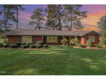 Brick ranch house with a well-maintained lawn at 739 Silk Hope Lindley Mill Rd, Siler City, NC 27344