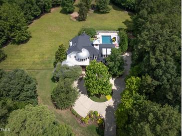 Aerial view of a home with a pool and circular driveway at 1153 Four Wheel Dr, Wake Forest, NC 27587