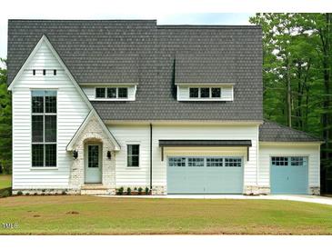 Modern farmhouse style home with large windows and light blue garage doors at 4345 Coldwater Springs Dr, Raleigh, NC 27616