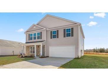 Two-story house with neutral exterior, stone accents, and a two-car garage at 310 Leven Dr, Gibsonville, NC 27249