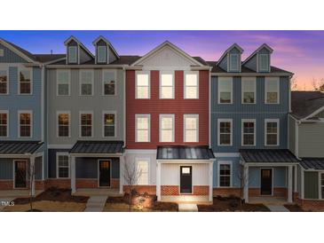 Three-story townhouses with brick and siding exteriors, showcasing a modern design at 121 Pearl St # 4, Garner, NC 27529