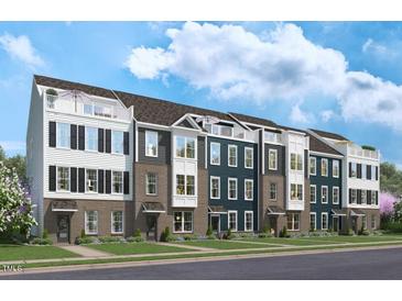 Three-story townhouses with brick and siding, balconies, and landscaping at 1500 Village Hall Ln # 39, Wake Forest, NC 27587
