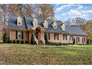 Brick ranch house with a large front yard and mature trees at 5021 Birchleaf Dr, Raleigh, NC 27606