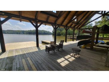 Relaxing boat dock with rocking chairs, canoes, and lake views at 171 Forest Bridge Rd, Youngsville, NC 27596