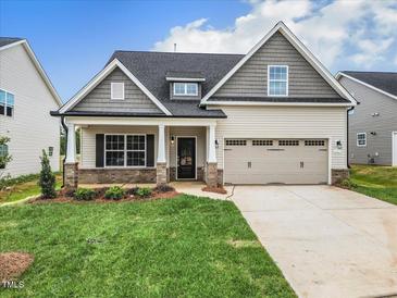 Two-story house with gray siding, brick accents, and a two-car garage at 1103 Nantucket Dr # 84, Mebane, NC 27302