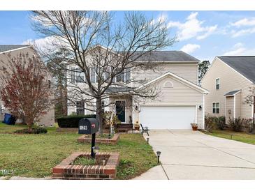 Two-story house with beige siding, attached garage, and landscaping at 128 Chownings Dr, Sanford, NC 27330