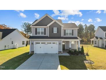 Two-story house with gray siding, white double garage door, and landscaped lawn at 41 Red River Dr, Selma, NC 27576