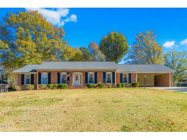 Brick ranch home with attached carport and landscaped lawn at 715 Engleman Ave, Burlington, NC 27215